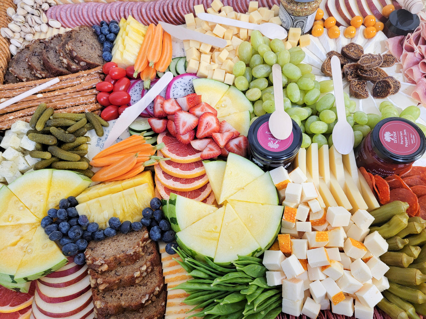 charcuterie spread featuring meats cheeses fruit vegetables and sweet bites