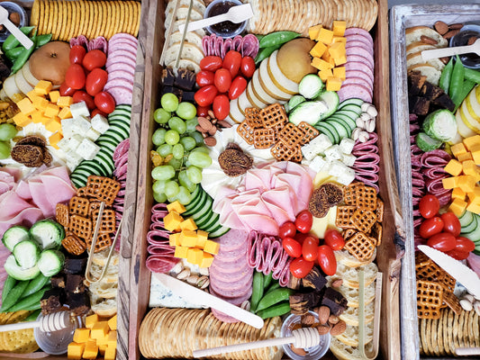 Assorted meats, cheeses, and vegetables on a wooden board