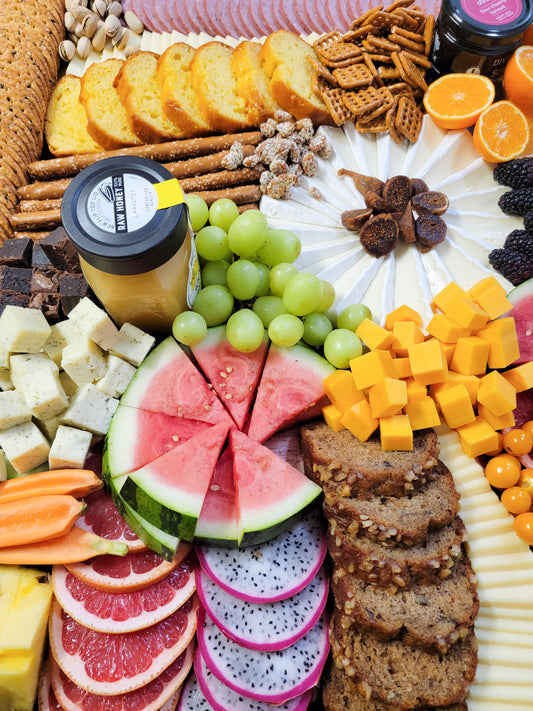 large grazing board with meats cheeses crackers fruit and nuts