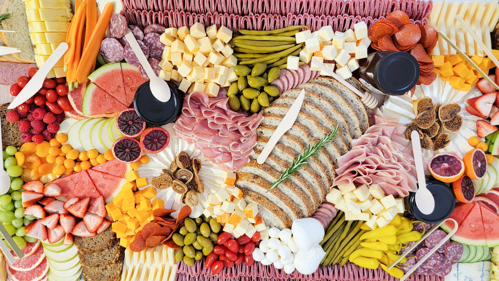 Extra large charcuterie board with assorted cured meats cheeses fruits and snacks for events